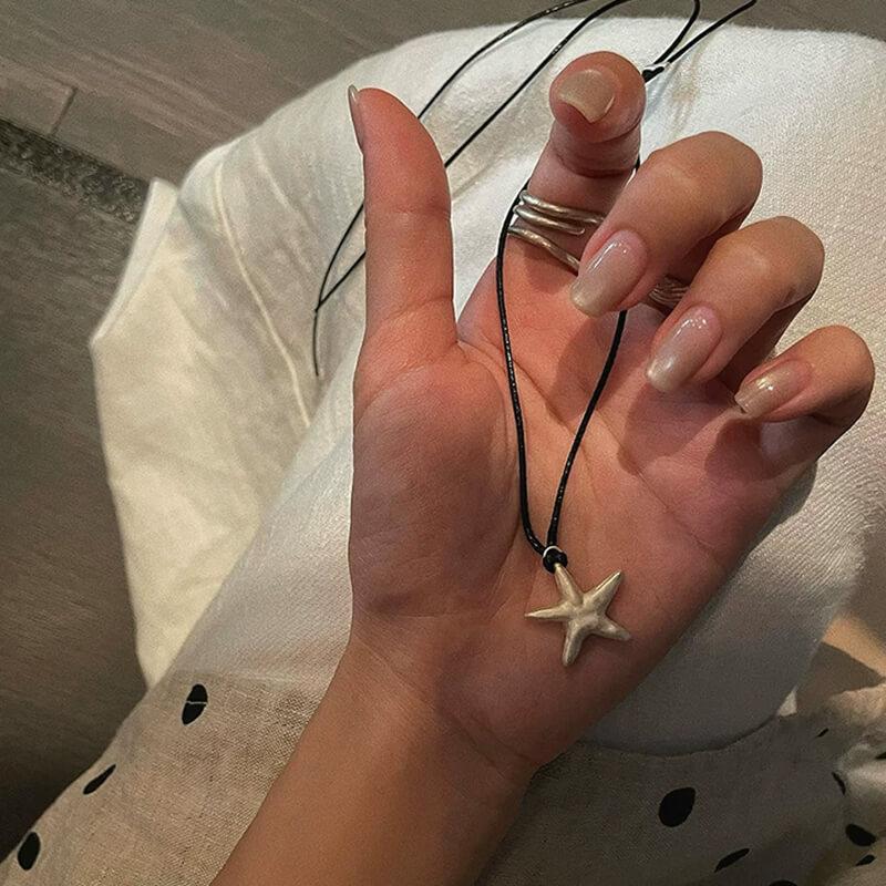 Original S990 Silver Starfish Necklace – Handmade Sandblasted Matte Finish with Black Cord — A minimalist starfish pendant in hand-sandblasted S990 silver, phot